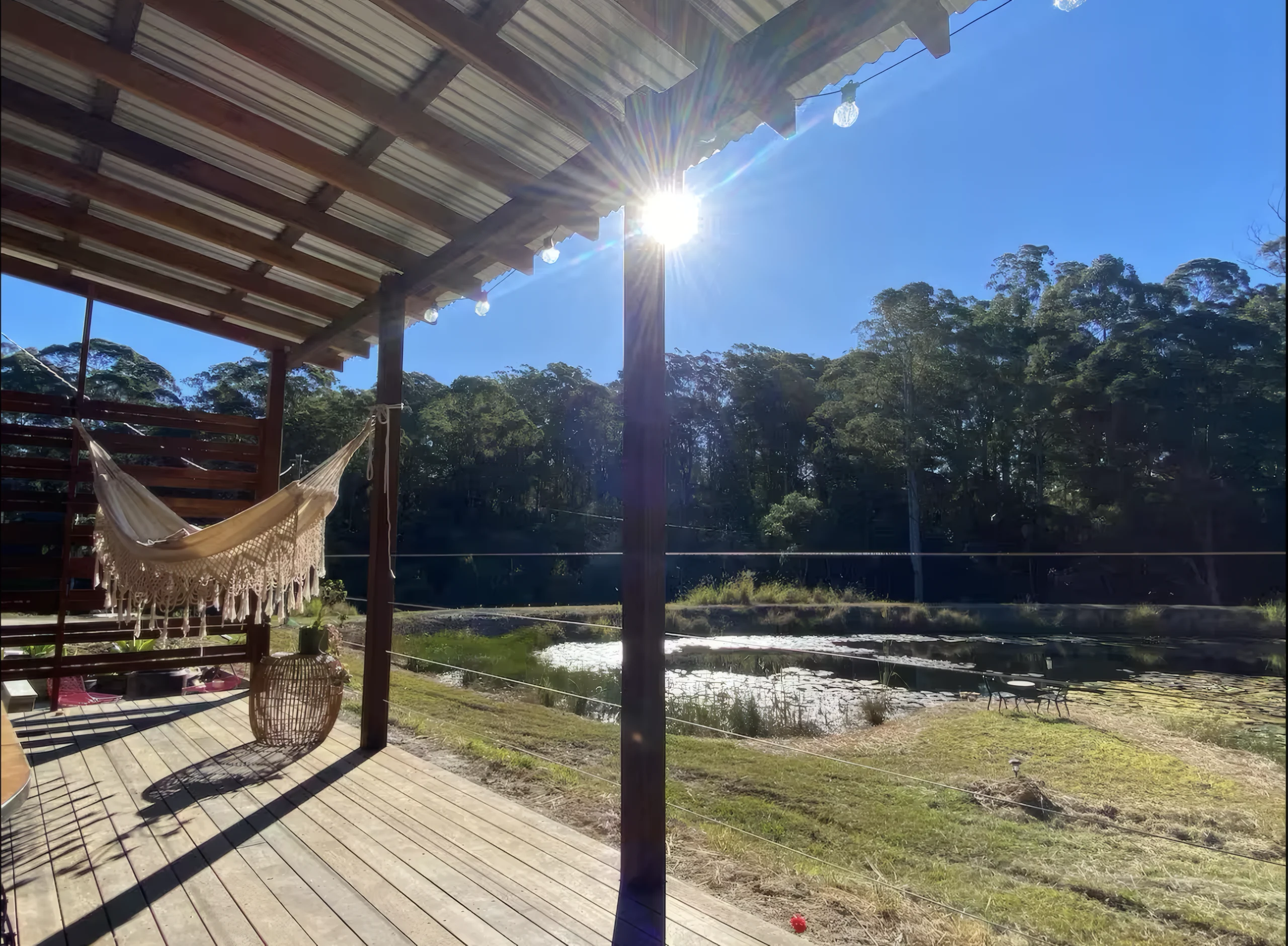 Morning sun over the deck, hammock and dam