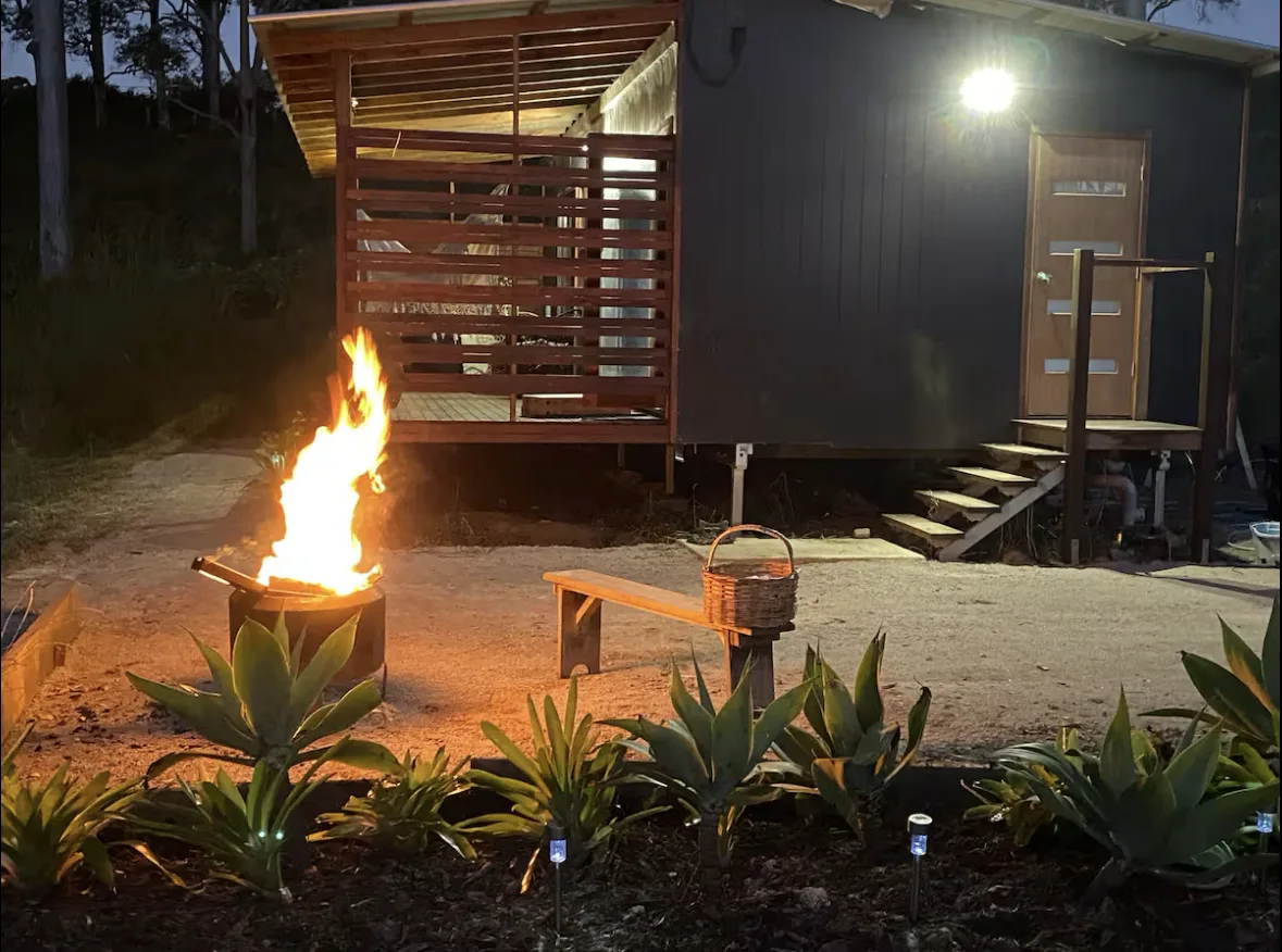 The fire pit burning outside the cabin at night