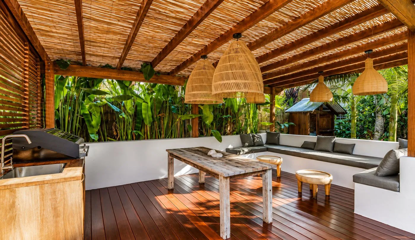 Outdoor entertaining deck with rattan pendants and tropical garden at The Murbah, managed by The Hosted Home Collective